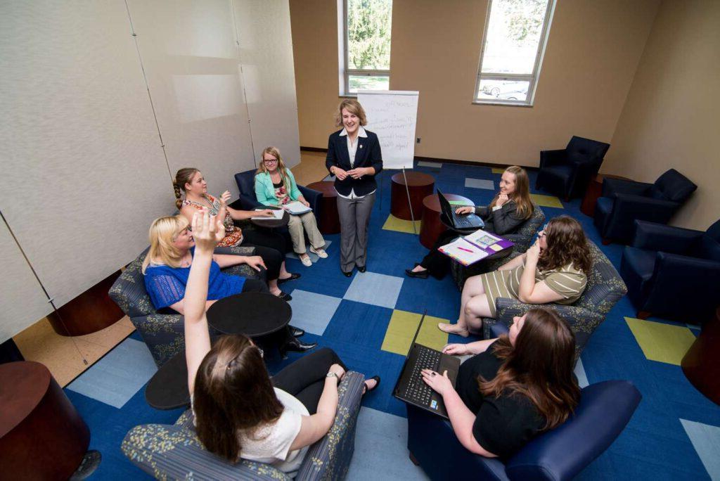 A group of female students in a circle having a 业务 meeting.